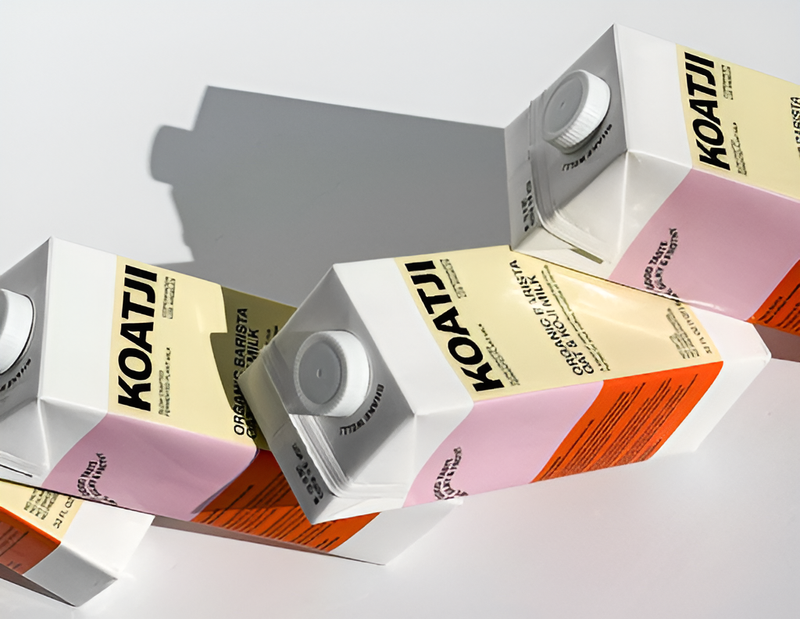 Koatji organic barista oat milk cartons arranged in a modern stacked layout with bold pastel packaging.